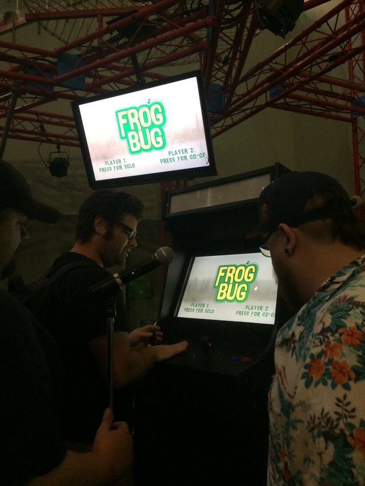 Players gathered around the FrogBug arcade cabinet at the Science Center